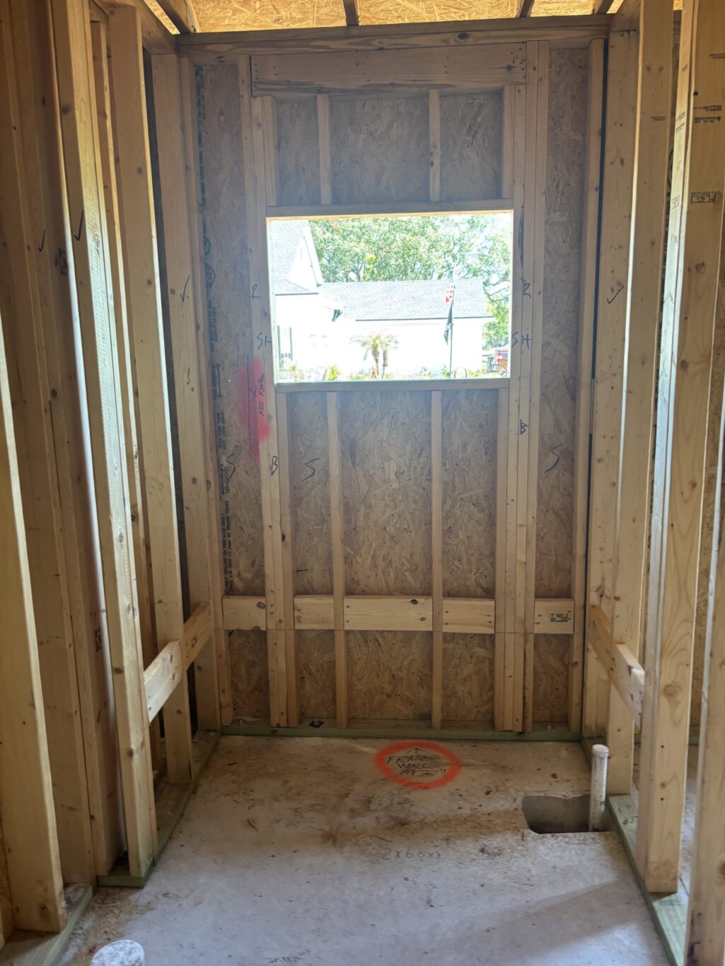 "Legacy Interior Services team member measuring subfloor for a custom shower pan installation in Jacksonville Florida"
